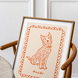 Może przedstawiać: Wydruk w ramie przedstawiający psa o imieniu Oscar. Pies jest narysowany w prostym, pomarańczowym stylu line art i siedzi z wystawionym językiem. Wydruk ma ozdobną ramkę z falistym brzegiem.