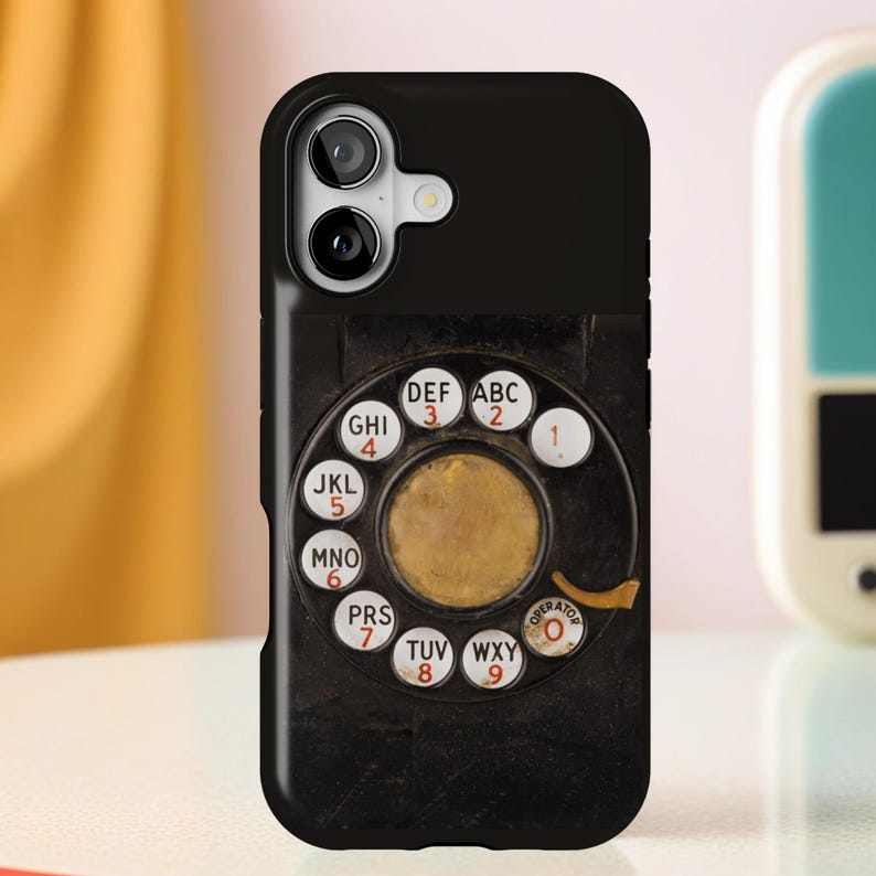 Pu&ograve; includere: Custodia per telefono nera con un design a disco rotante. Il quadrante ha pulsanti numerici bianchi e un centro dorato. La custodia ha un ritaglio per la fotocamera ed &egrave; progettata per adattarsi a uno smartphone.