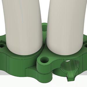 May include: Green plastic pipe connector with two white pipes attached. The connector has a hole in the center and a screw on each side.