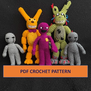 以下が含まれることがあります： 黄色いウサギ、紫色のキャラクター、緑色のアニマトロニクス、そして2体の灰色のキャラクターを含む、5体の編みぐるみ。おもちゃは黒い背景に一列に並んでいます。PDF CROCHET PATTERNはオレンジ色のバナーに白い文字で書かれています。