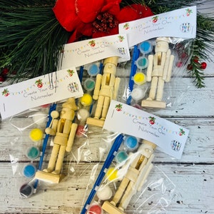 May include: Four sets of wooden nutcracker figurines with paint and brushes in clear plastic bags. Each bag has a label that says "Create Your Own Nutcracker".