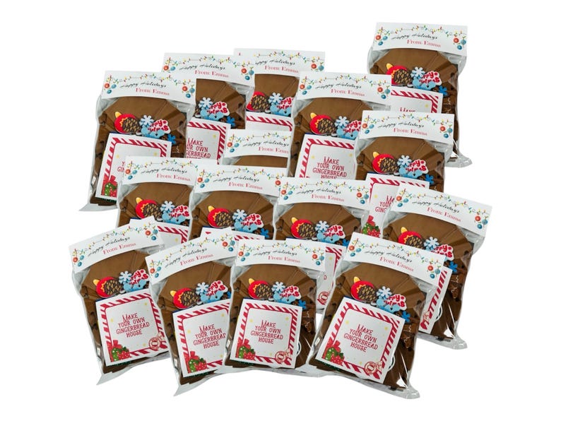 May include: Multiple clear plastic bags containing gingerbread house kits. Each bag has a brown gingerbread house base, decorative candies, and a card that reads "Make Your Own Gingerbread House". The bags are sealed with a festive holiday design.