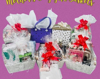 May include: Five gift baskets decorated with red bows and white tissue paper. The baskets contain various items, including bath products, candles, and books. The baskets are arranged on a pink surface with the text "Mother's Day Gift Baskets" at the top of the image.