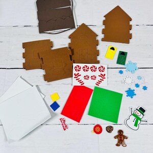 May include: A gingerbread house kit with brown house pieces, white icing sheets, and colorful decorations. Includes red, green, and yellow accents, candy cane stickers, and a snowman. Perfect for a festive holiday activity.