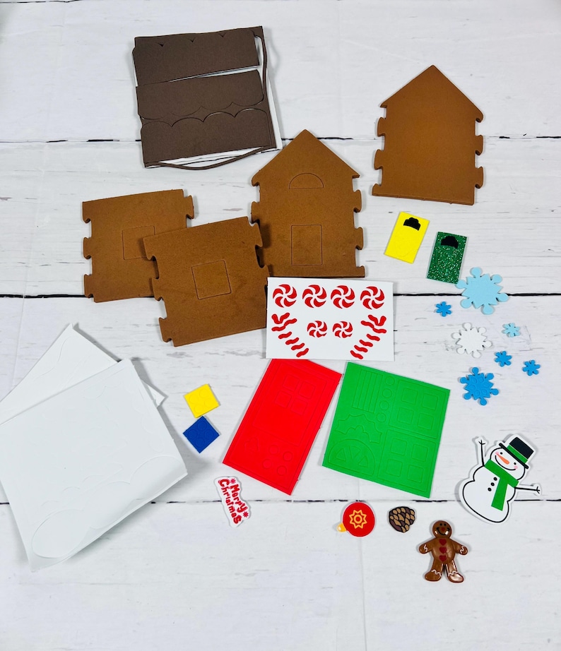 May include: A gingerbread house kit with brown house pieces, white icing sheets, and colorful decorations. Includes red, green, and yellow accents, candy cane stickers, and a snowman. Perfect for a festive holiday activity.