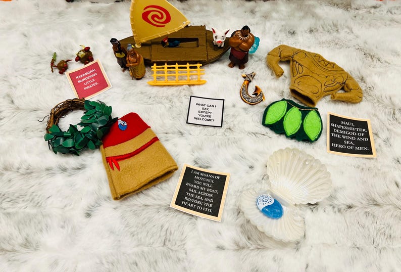 May include: A collection of felt crafts inspired by the Disney movie Moana. The set includes a felt boat, a felt Maui, a felt Moana, a felt seashell, and a felt lei. The felt crafts are all handmade and feature intricate details.