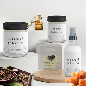 May include: A collection of caramel tobacco scented products, including candles, wax melts, and a room spray. The products are in clear glass jars and bottles with black lids and labels. Caramel candies are in the foreground.