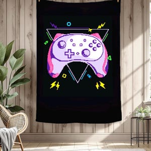 May include: Black wall tapestry featuring a pixelated video game controller in shades of purple and pink. The controller is set against a black background with geometric shapes and lightning bolt accents, perfect for a gamer's room.