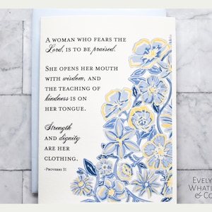 May include: Greeting card with floral design in blue and yellow. The card features the text "A woman who fears the Lord, is to be praised." Additional text includes "Strength and dignity are her clothing." The card is from Evelyn Whatley & Co.