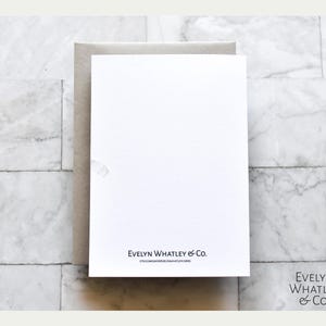 May include: A blank white card with a light gray envelope. The card has the text "Evelyn Whatley & Co." printed in black at the bottom.