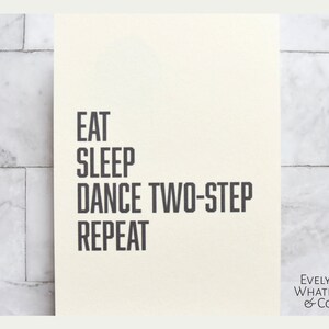 May include: A white card with black text that reads "Eat, Sleep, Dance Two-Step, Repeat". The card is signed "Evelyn Whatley & Co."