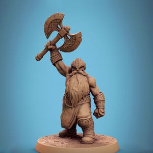 May include: A detailed figurine of a dwarf, viewed from the back, holding a large double-bladed axe above his head. The dwarf has a long beard, helmet, and armor. The figurine is brown and stands on a circular base.
