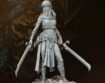 May include: A grey miniature figure of a warrior woman holding two curved swords. She wears a head covering, a crop top, and wrapped leg coverings. The figure stands on a circular base, with a detailed background.