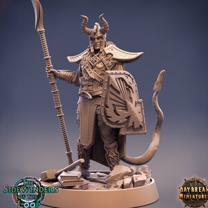 Op de afbeelding: Gedetailleerd beeldje van een krijger in sierlijk harnas, met een speer en schild. De figuur draagt een gehoornde helm en poseert op een rotsachtige basis. Het schild heeft een gestileerd ontwerp. De basis bevat de tekst "The Sidewinders of the Loop" en "Daybreak Miniatures".
