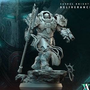 May include: A detailed, gray miniature figure of a heavily armored warrior, holding a staff-like weapon. The figure stands on a rocky base, with the text "SACRAL KNIGHTS DELIVERANCE" and "BASTION OF LIGHT 3" visible. The figure is from A Games.