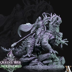 Puede incluir: Una figura miniatura pintada en gris de un guerrero montando un dragón. El guerrero lleva armadura y sostiene una lanza. El dragón tiene una boca grande y garras afiladas. La miniatura está colocada sobre una base rocosa. El logotipo de The Queen's Web Underworld es visible en la esquina inferior izquierda.