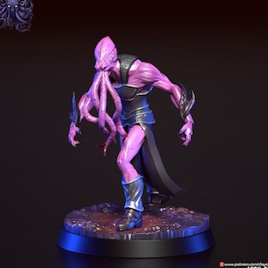 Peut inclure: Une figurine miniature peinte en rose et violet d'un illithide, une créature de Donjons et Dragons, avec le texte "Quel'Zora" au-dessus. La figurine est posée sur une base noire avec une surface texturée rouge et brune.