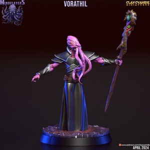 Peut inclure: Une figurine miniature peinte d'un humanoïde à la peau violette avec des tentacules pour cheveux, portant une robe noire et tenant un bâton avec un joyau vert au sommet. La figurine est posée sur une base noire avec une surface texturée violette et brune. Le texte "VORATHIL" est écrit en lettres blanches au-dessus de la figurine.