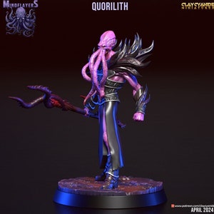 Peut inclure: Une figurine miniature de Quorilith, une créature de l'univers de Donjons et Dragons, de couleur violette et noire. La figurine tient un bâton avec un sommet incurvé en forme de tentacule. Le Quorilith a un corps humanoïde avec une grosse tête tentaculaire.