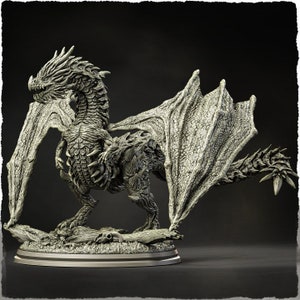 May include: A detailed grey dragon figurine with textured wings and scales. The dragon is posed on a base with a skull and wood details. The sculpture has a menacing expression and is a fantasy-themed collectible.