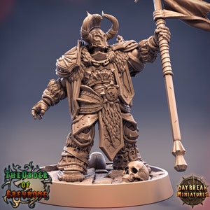 Puede incluir: Una figura miniatura de un guerrero con armadura y sosteniendo una bandera. El guerrero tiene cuernos y barba. La figura est&aacute; pintada de color marr&oacute;n y est&aacute; de pie sobre una base. La base tiene una calavera y una textura de piedra. El texto "The Order of Greybone" es visible en la base.