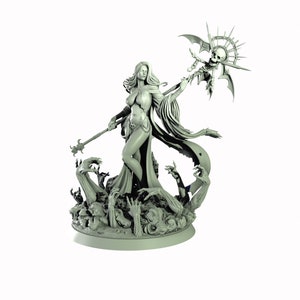 May include: A gray painted miniature figurine of a female figure with long flowing hair, wearing a flowing robe and holding a staff with a skull and wings at the top. The figure is standing on a base with sculpted hands reaching up from the ground.