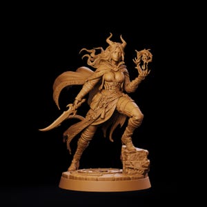 May include: A monochromatic tan figurine of a horned female warrior standing on a stone base. The figure wears a cloak, armor, and boots, holding a curved blade in one hand and a glowing magical key-like object in the other, with flowing hair.