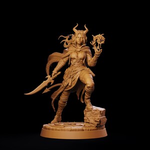 May include: A monochromatic tan figurine of a horned character standing on a stone base. The figure wears a cloak and layered clothing, holding a curved blade in one hand and a swirling magical effect in the other, with a tail visible behind.