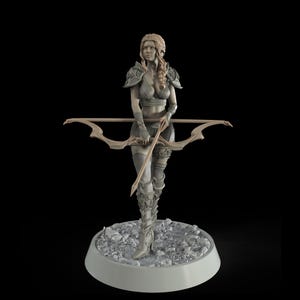May include: A gray painted figurine of a woman with long blonde hair, wearing armor and holding a bow and arrow. The figurine is standing on a gray base with a rough texture.