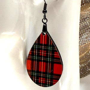 May include: A single teardrop-shaped earring with a red and black plaid pattern. The earring has a black metal hook and a black metal accent piece. The plaid design includes red, black, and green lines.