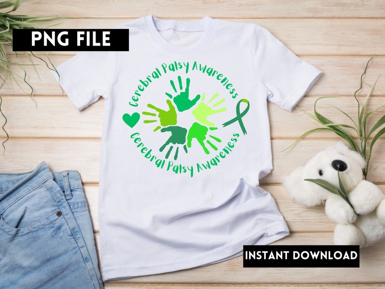 Puede incluir: Camiseta blanca con un dise&ntilde;o de huellas de manos verdes y amarillas y el texto "Cerebral Palsy Awareness". El dise&ntilde;o incluye un coraz&oacute;n verde y una cinta verde.