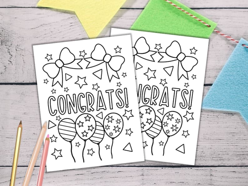 Puede incluir: Dos tarjetas para colorear imprimibles en blanco y negro con la palabra "&iexcl;Felicidades!" y un dise&ntilde;o de globos, estrellas y lazos.