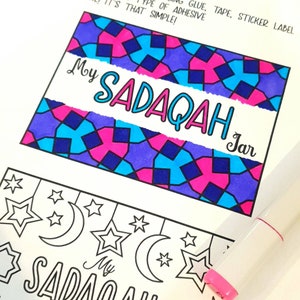 May include: A printable design for a "My Sadaqah Jar" label. The design features a colorful geometric pattern in shades of blue, pink, and purple. The text "My Sadaqah Jar" is written in a white banner across the design.