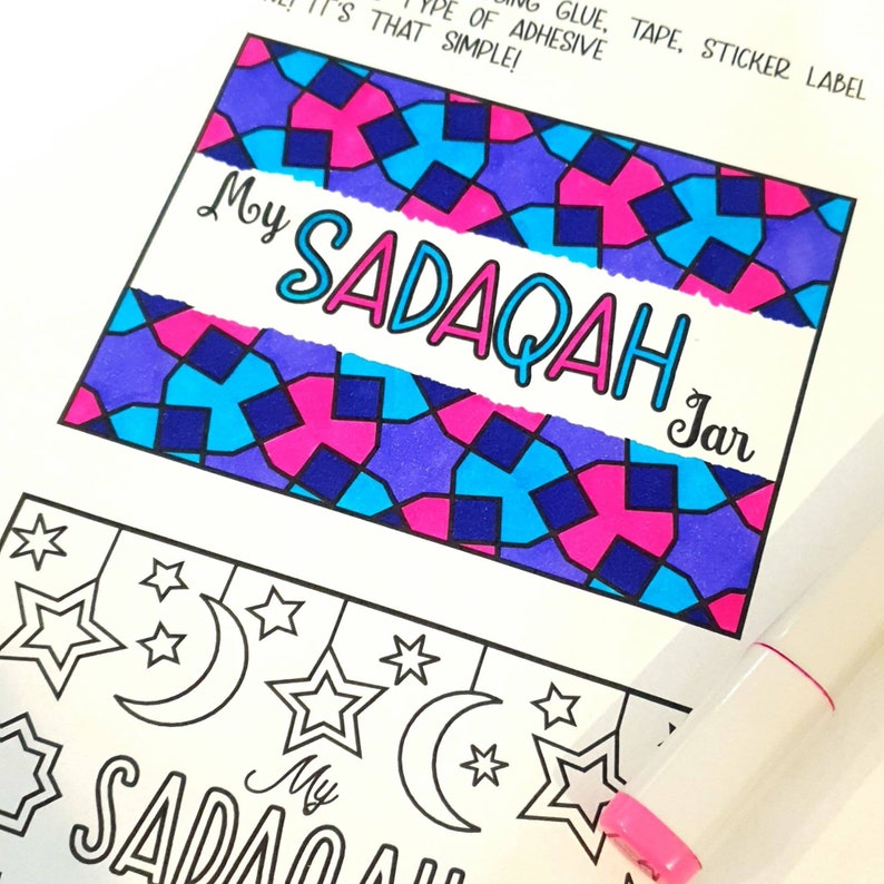 May include: A printable design for a "My Sadaqah Jar" label. The design features a colorful geometric pattern in shades of blue, pink, and purple. The text "My Sadaqah Jar" is written in a white banner across the design.