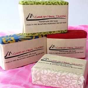May include: Four bars of handmade silk soap with a floral design on the top and a white label with the text "GANESH HIMAL TRADING" and "Handmade Silk Soap" on the front. The soap is cruelty-free, made with natural ingredients, and fair trade.