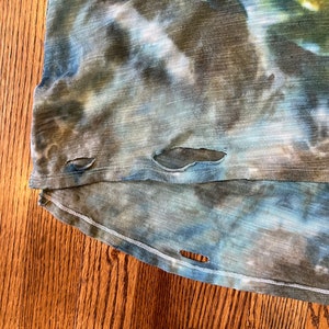May include: A blue and green tie-dye shirt with several small holes in the fabric.