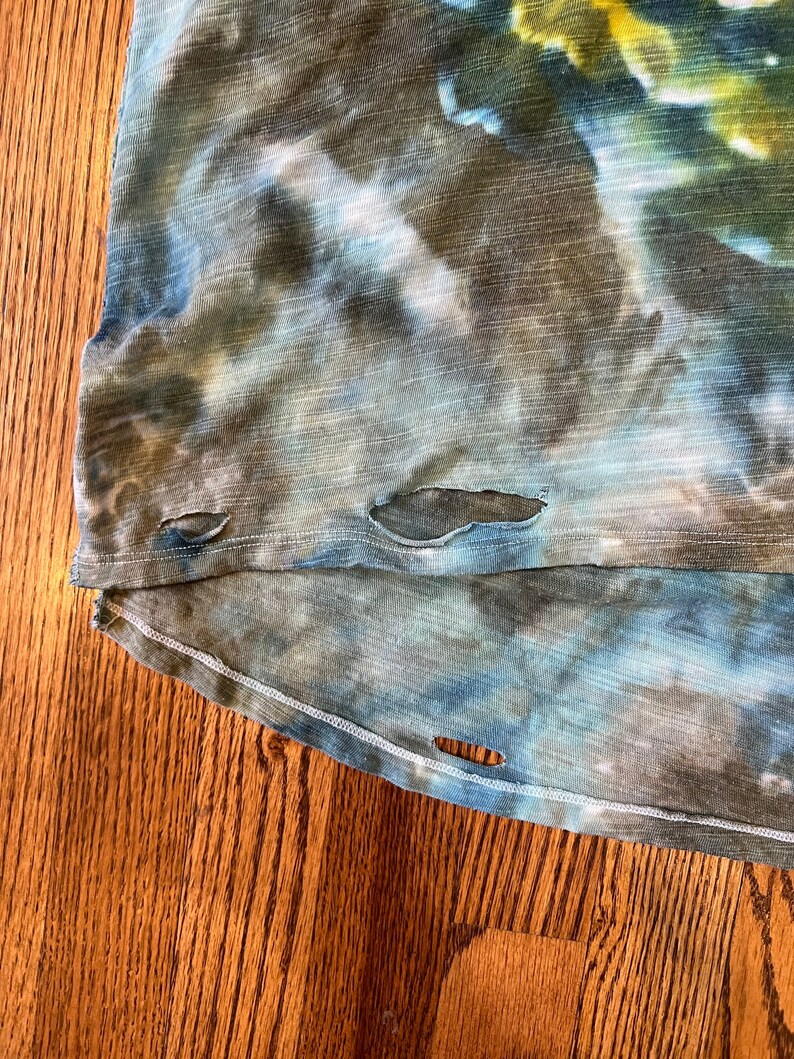 May include: A blue and green tie-dye shirt with several small holes in the fabric.