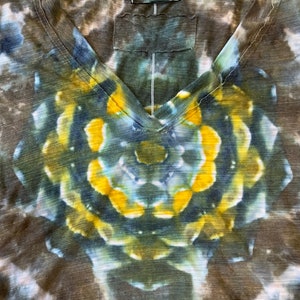 May include: A brown, blue, and yellow tie-dye V-neck t-shirt with a circular pattern. The shirt has a "The Face" tag on the neck.