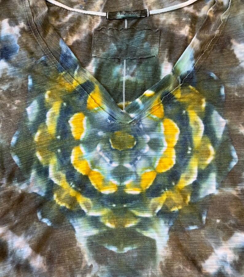 May include: A brown, blue, and yellow tie-dye V-neck t-shirt with a circular pattern. The shirt has a "The Face" tag on the neck.