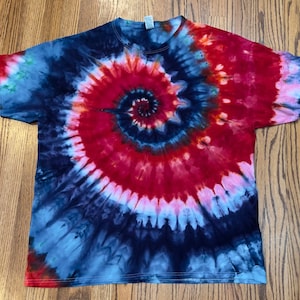 May include: A tie-dye t-shirt with a red, blue, and white spiral pattern.