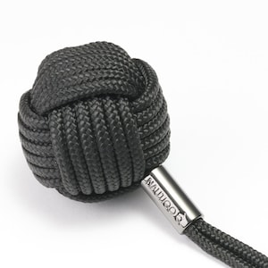 以下が含まれることがあります： 「MALIGOO」と刻印された銀色の金属タグが付いた、黒色の結び目のあるロープのキーホルダーです。