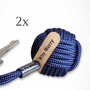 Könnte beinhalten: Ein Schlüsselanhänger aus dunkelblauem Seil mit einem Lederanhänger mit der Aufschrift "Why Worry".