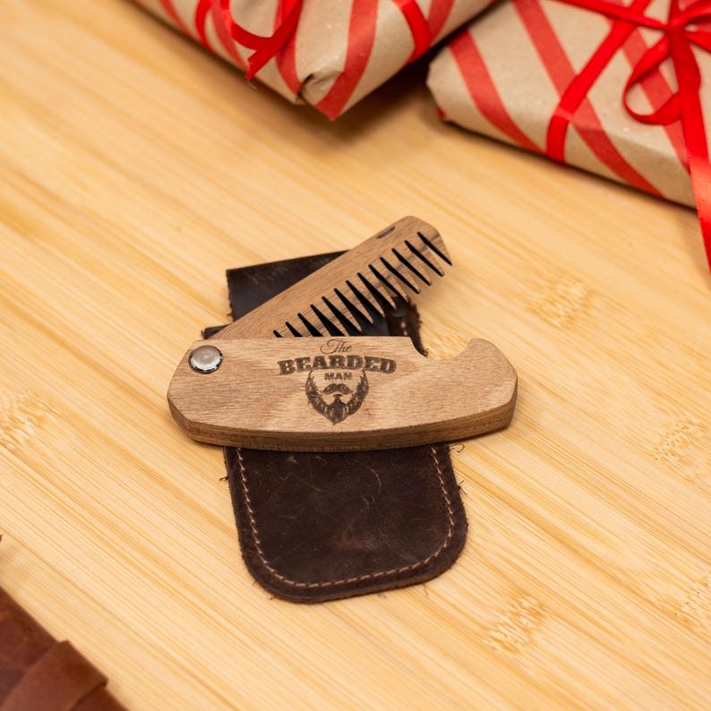 May include: A wooden beard comb with a leather case. The comb has a built-in bottle opener and is engraved with the words "The Bearded Man".