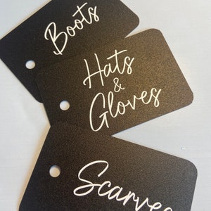 May include: Three black gift tags with white text. The tags are labelled "Boots", "Hats & Gloves", and "Scarves".