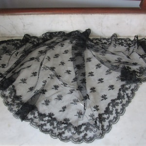 Puede incluir: Chaleco de encaje negro con borde festoneado y estampado floral.