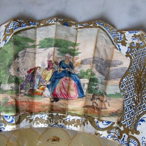 Ventaglio elisabettiano con aste di cartilagine e rilievi dorati. Paese di carta dipinto con acquerello e oro