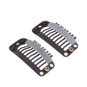 May include: Two brown metal hair clips with a gray rubber strip on each. The clips have a row of teeth on one side and a small hole on the other.