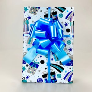 May include: A wrapped gift with a blue bow. The gift wrap is white with a pattern of blue, silver, and black gift boxes, stars, and shooting stars. The bow is a bright, shiny blue.