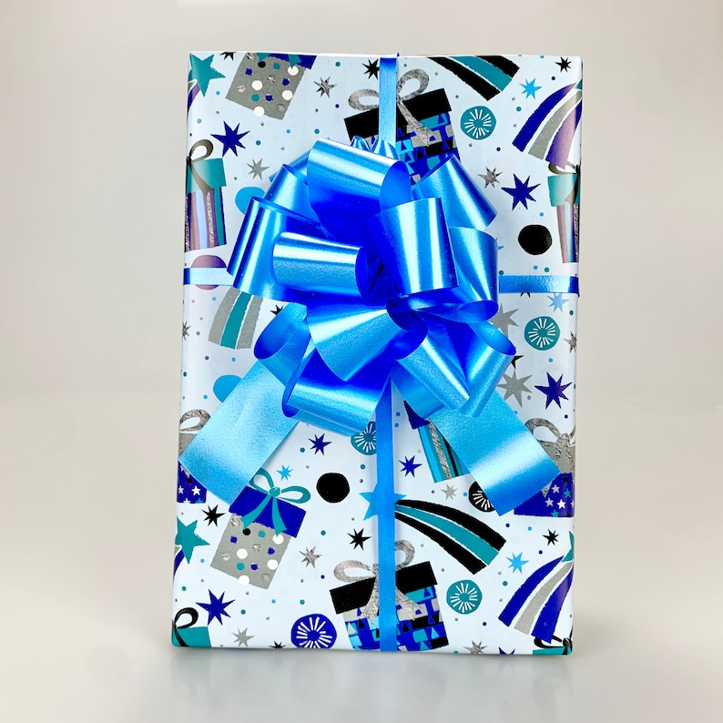 May include: A wrapped gift with a blue bow. The gift wrap is white with a pattern of blue, silver, and black gift boxes, stars, and shooting stars. The bow is a bright, shiny blue.