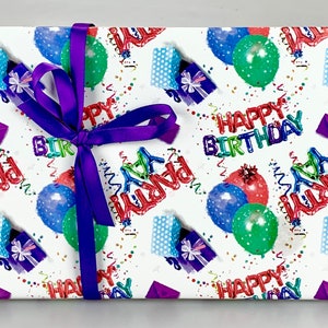 May include: A wrapped gift with a purple ribbon. The wrapping paper is white with a colorful birthday theme, featuring balloons, gift boxes, confetti, and the words "Happy Birthday" and "Party".